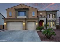 Elegant two-story home featuring a three-car garage, beautifully landscaped front yard and a red front door at 12910 W Tuckey Ln, Glendale, AZ 85307