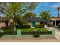 Charming home with a well-maintained front yard, a blue front door, and a stylish fence at 1326 E Almeria Rd, Phoenix, AZ 85006
