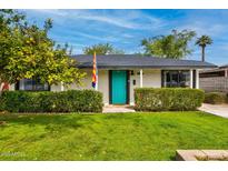 Charming single story house with a lush green lawn and a vibrant turquoise door at 1326 E Almeria Rd, Phoenix, AZ 85006