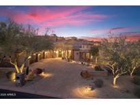 Beautiful home at twilight with a brick driveway, desert landscaping, and exterior lighting at 15956 E Tombstone Trl, Fountain Hills, AZ 85268