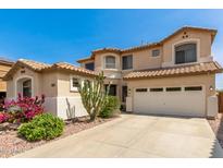 Two-story tan home features tile roof, desert landscaping, and a two car garage at 17005 S Coleman St, Phoenix, AZ 85045
