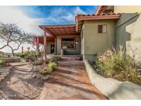 Inviting front entrance with a charming walkway and lush desert landscaping under a covered patio, ideal for outdoor relaxation at 3201 N 91St St, Mesa, AZ 85207