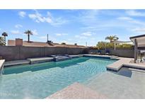 This backyard features a sparkling pool, complete with tanning ledges and a soothing waterfall feature at 4129 W Caron St, Phoenix, AZ 85051