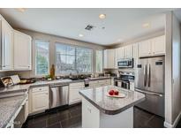 Bright kitchen featuring white cabinets, granite countertops, stainless steel appliances, and a center island at 4465 E Paradise Village S Pkwy # 1133, Phoenix, AZ 85032