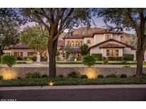 Elegant two-story home featuring a red tile roof, manicured landscaping, and stone accents against a mountain backdrop at 5902 E Arcadia Ln, Phoenix, AZ 85018