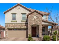Charming two-story home features a stone facade, attached two-car garage, and manicured landscaping at 10162 E Theorem Dr, Mesa, AZ 85212