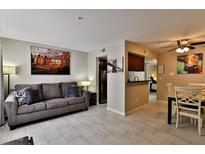 Inviting living room featuring a comfortable couch, artwork, and tile flooring at 12123 W Bell Rd # 218, Surprise, AZ 85378