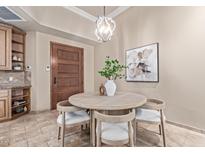 Cozy dining area featuring a round wood table, stylish chandelier, and neutral decor at 12625 N Saguaro Blvd # 203, Fountain Hills, AZ 85268