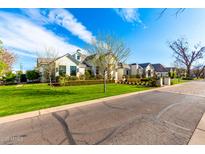 Beautiful exterior view of a single-Gathering home with a large lawn, mature landscaping, and brick driveway at 20690 E Sunset Dr, Queen Creek, AZ 85142