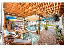 Relaxing backyard under wood pergola with lounge area, built in bar, and a refreshing swimming pool at 3126 N 17Th Dr, Phoenix, AZ 85015