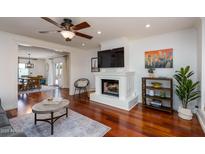 Cozy living room featuring a fireplace, modern decor, hardwood floors, and open access to the dining area at 3514 N 83Rd St, Scottsdale, AZ 85251