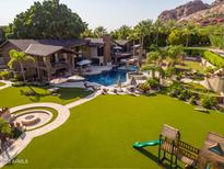Lush backyard featuring a large lawn, seating areas, multiple entertaining spaces, mountain views, and outdoor recreation at 5040 N Arcadia Dr, Phoenix, AZ 85018