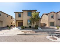 Tan two-story home with a two-car garage and simple desert landscaping at 5233 W Albeniz Pl, Phoenix, AZ 85043