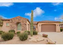 Charming home featuring desert landscaping, a stone archway, and a spacious two-car garage at 8367 W Lariat Ln, Peoria, AZ 85383