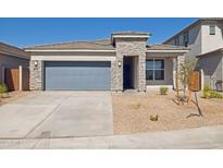 Beautiful single-story home with a blue garage door and stone accents at 17825 W Mission Ln, Waddell, AZ 85355