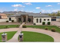 Beautiful home featuring a circular driveway, manicured lawn, and stunning mountain views in the background at 19717 E Country Meadows Dr, Queen Creek, AZ 85142