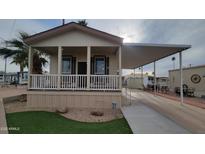 Charming single story home with covered porch, manicured lawn, and a convenient carport at 2460 E Main St # F7, Mesa, AZ 85213