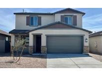 Two-story home featuring a spacious two-car garage, neutral colors, and low maintenance landscaping at 25215 W Wayland Dr, Buckeye, AZ 85326