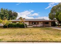 Charming single-story home featuring mature landscaping and a covered carport with a brick-accented facade at 4249 E Mitchell Dr, Phoenix, AZ 85018