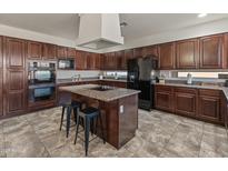 Well-equipped kitchen boasts dark wood cabinetry, granite countertops, and a functional center island at 5917 N 133Rd Ave, Litchfield Park, AZ 85340