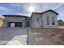 Stunning stone and stucco exterior featuring a spacious garage and inviting entryway at 6790 S Springs Pl, Chandler, AZ 85249