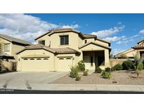 Two-story home featuring a three-car garage and a well-maintained, xeriscaped front yard, perfect for low-maintenance living at 7511 S 45Th Dr, Laveen, AZ 85339