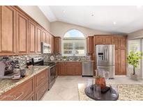 Well-lit kitchen featuring granite countertops, stainless steel appliances, and custom cabinetry at 8804 E Sunnyside Dr, Scottsdale, AZ 85260