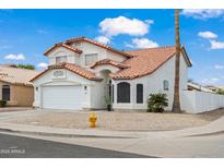Two-story home featuring a red tile roof, a two car garage, and desert landscaping at 9818 W Pontiac Dr, Peoria, AZ 85382