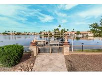 A lake view with a boat, landscaping, and a patio leading to the water at 11101 W Sieno Pl, Avondale, AZ 85392