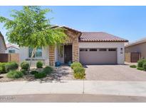 Charming single-story home featuring a brick facade, desert landscaping, and a two-car garage at 24878 N 172Nd Dr, Surprise, AZ 85387