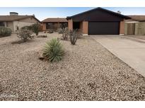 Southwest home with desert landscaping, rock ground cover, and a two-car garage at 4111 W Desert Cove Ave, Phoenix, AZ 85029