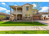 Beautiful two-story home featuring a balcony, stone accents, a well-manicured lawn and attached garage at 4237 E Sierra Madre Ave, Gilbert, AZ 85296