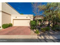 Charming home featuring a two-car garage, desert landscaping, and lovely curb appeal on a sunny day at 6701 N Scottsdale Rd # 15, Scottsdale, AZ 85250