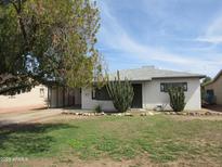 Charming single-story home with a well-maintained lawn and desert landscaping including mature cactus at 6711 N 32Nd Dr, Phoenix, AZ 85017