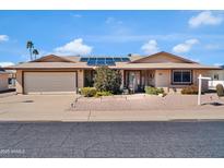 Charming home features a neutral color palette, solar panels, and well-maintained desert landscaping at 10842 W Sarabande Cir, Sun City, AZ 85351