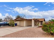 Charming single-story home featuring a covered carport, desert landscaping, and attached garage at 1531 E El Parque Dr, Tempe, AZ 85282