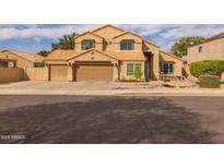 Charming two-story home featuring a three-car garage, tile roof, well-maintained landscaping, and a cozy front entryway at 1648 S Faith --, Mesa, AZ 85209