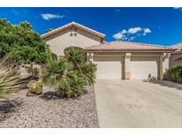 Beige home with tile roof and desert landscaping, including small palm trees, gravel, and a two-car garage at 2535 N Pinnule Cir, Mesa, AZ 85215