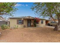 Charming single-story home features a red floral shrub and a cozy front yard under a bright blue sky at 2916 W Pierce St, Phoenix, AZ 85009