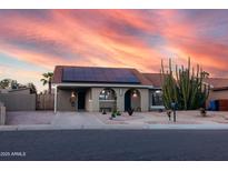 Charming single-story home with Southwestern landscaping and solar panels at dusk at 614 W Morrow Dr, Phoenix, AZ 85027
