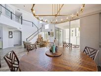 Dining area showcasing a large wood table and a stylish chandelier, with views of the spacious living room at 9390 N 115Th St, Scottsdale, AZ 85259