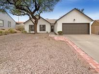 Charming single-story home features a well-maintained exterior and a tidy front yard with a large tree for shade at 9817 S 47Th Pl, Phoenix, AZ 85044