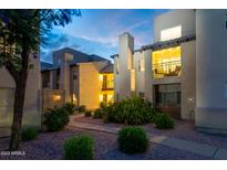 Charming condo exterior with landscaped grounds and cozy balcony lighting at 14145 N 92Nd St # 2077, Scottsdale, AZ 85260
