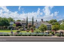 Charming home with a lush front yard, white picket fence, and vibrant rose bushes at 5431 E Lafayette Blvd, Phoenix, AZ 85018