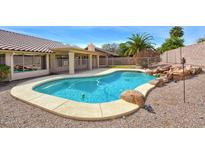 Inviting backyard pool with rock accents, surrounded by a fence and mature landscaping, perfect for relaxation and entertainment at 604 W Villa Rita Dr, Phoenix, AZ 85023