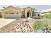 Inviting single-story home with desert landscaping, complemented by a two-car garage and tiled roof at 832 N Blue Marlin Dr, Gilbert, AZ 85234