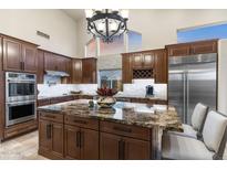 This kitchen features a large island, stainless steel appliances and custom cabinets at 11053 E Hedgehog Pl, Scottsdale, AZ 85262