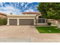 Two-car garage with a neutral color scheme, complemented by lush landscaping and a well-maintained lawn at 1210 E Azure Sea Ln, Gilbert, AZ 85234