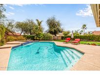 Inviting pool with lounge chairs and lush landscaping creates a backyard oasis at 15027 N 61St Pl, Scottsdale, AZ 85254