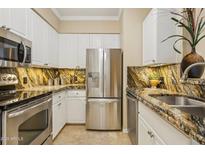 Modern kitchen with stainless steel appliances, granite countertops, and white cabinetry at 1701 E Colter St # 311, Phoenix, AZ 85016
